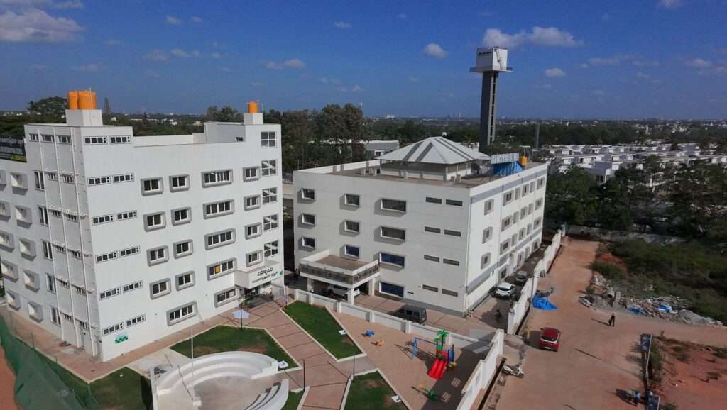 Aerial drone view of the Vidya Siri College of Pharmacy building and surrounding campus ground