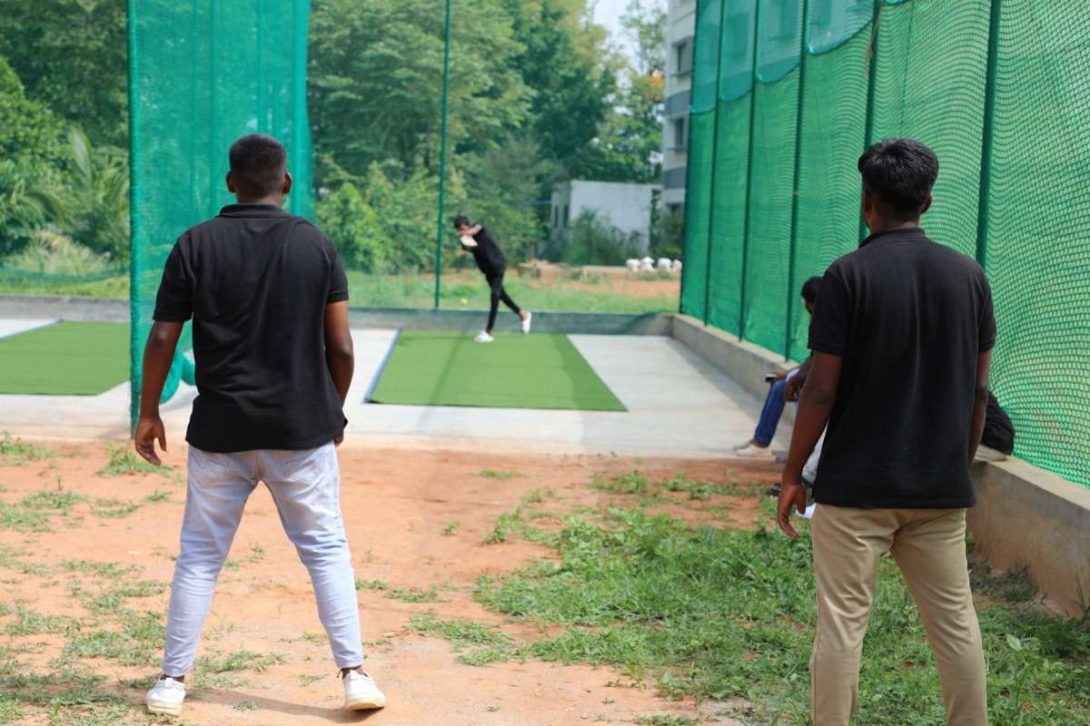Students playing cricket at Vidya Siri College of Pharmacy sports ground
